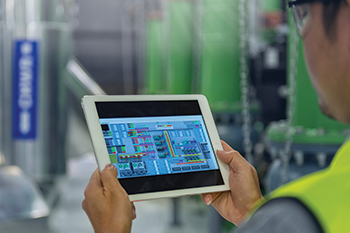 HVAC technician using a tablet to monitor a building control system